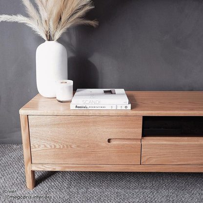 Daphne 200cm American Oak and Timber Entertainment Unit Natural, showcasing sleek, curved corners and striking wood grain patterns, highlighted against a backdrop of a white vase with dried flowers.