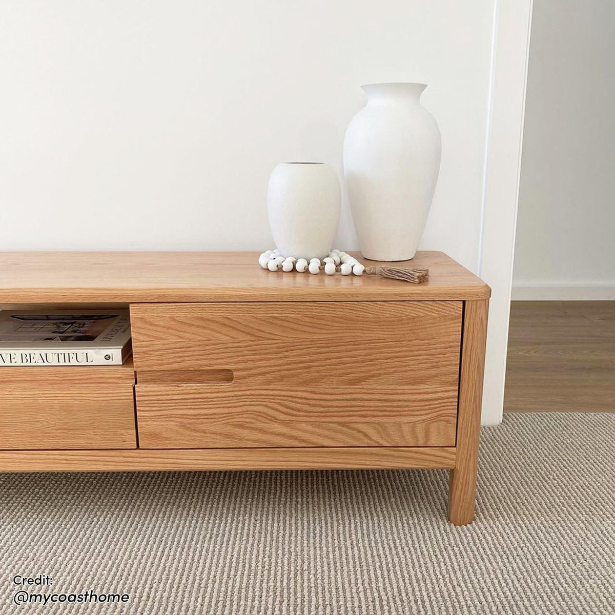 Daphne 200cm American Oak and Timber Entertainment Unit Natural showcasing sleek, curved lines and prominent wood grain patterns with spacious compartments and drawers, highlighting its Scandinavian-inspired design and robust construction.