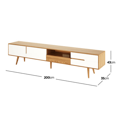 Estella 200cm American Oak Entertainment Unit in Natural features a mid-century-inspired design with light wood, white-fronted storage, slender splayed legs, sliding doors, open shelf, and drawers, offering elegant practicality.