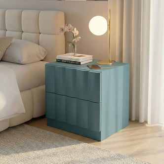 Hamish 2 Drawer Fluted Bedside Table in Sage with curved fluted front, displayed beside bed with lamp, books and phone on top