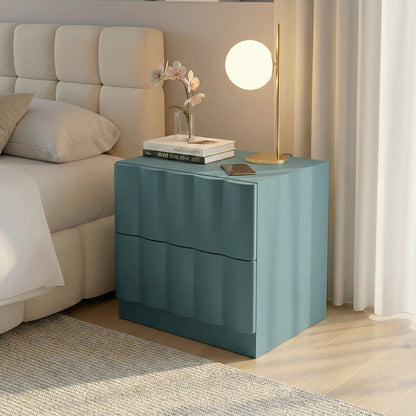 Hamish 2 Drawer Fluted Bedside Table in Sage with curved fluted front, displayed beside bed with lamp, books and phone on top