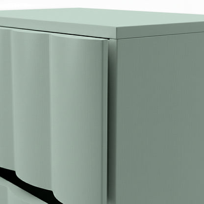 Close-up of sage green bedside table showing fluted drawer front and top edge detail