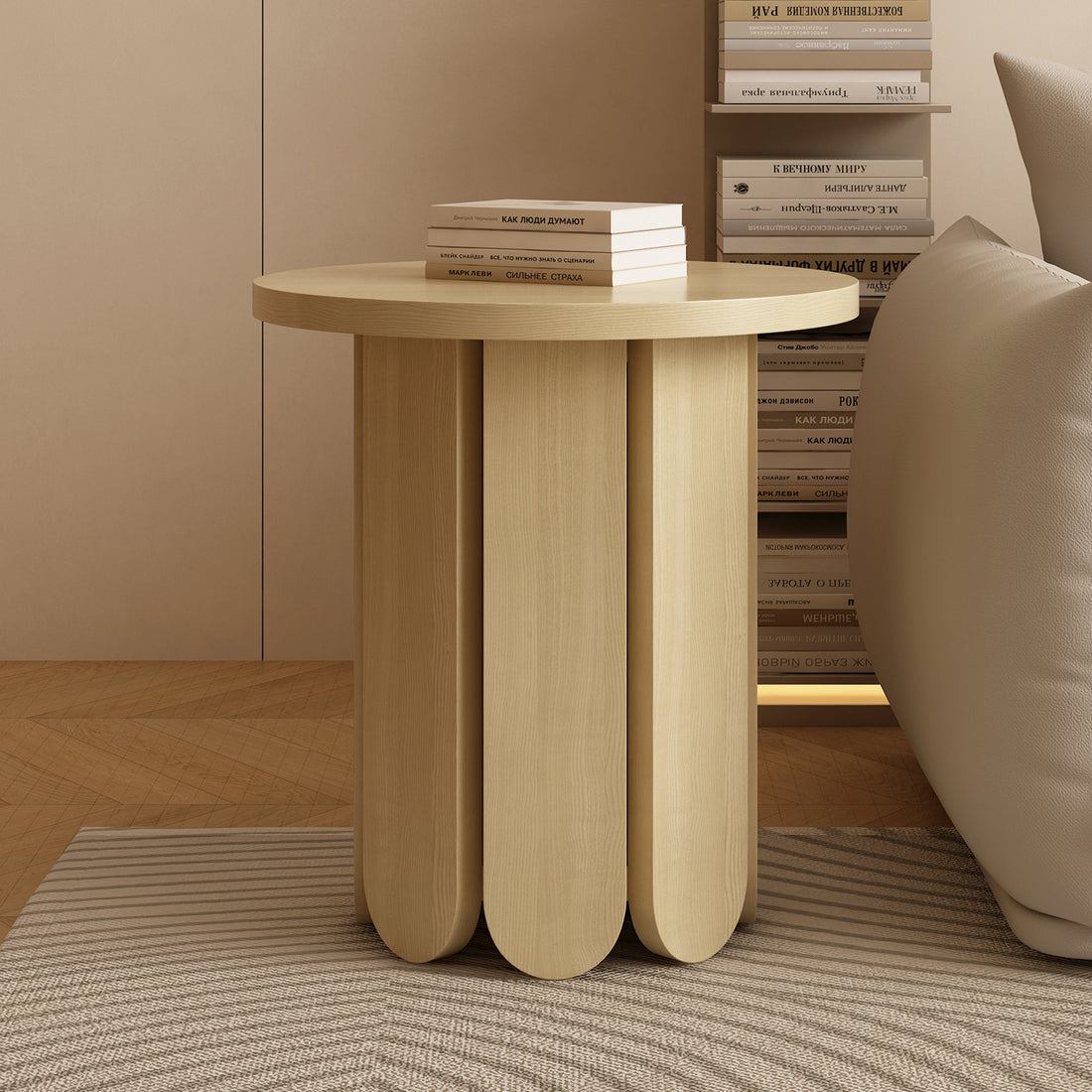 Hugo 45cm Round Side Table with Curve Detail in Natural, featuring a petal-like base and light wood finish, complemented by a stack of books, set in a minimalist living-room corner.