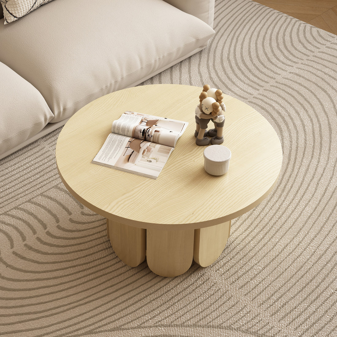 Hugo 70cm round coffee table in natural ash wood with three curved legs, styled with magazine, figurine and small white