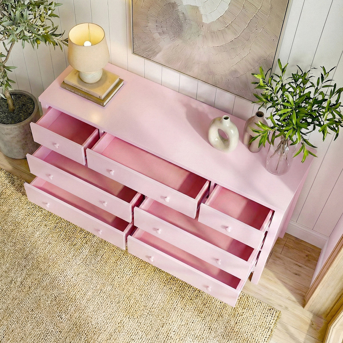 Pink Serra 7-drawer lowboy dresser with open drawers in styled room