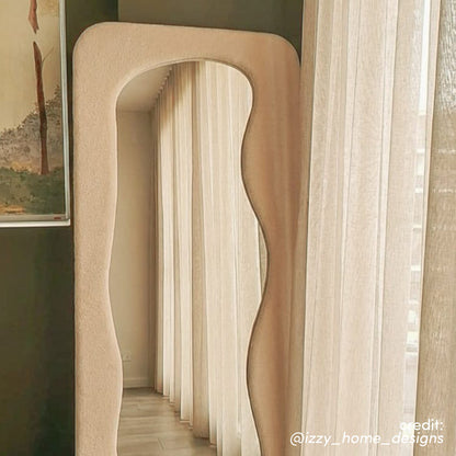Sabrina 180cm Curved Full Length Mirror in Beige with wavy frame and textured finish, reflecting sheer curtains and hallway