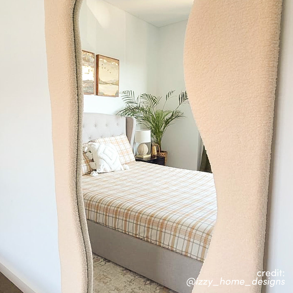 Sabrina 180cm Curved Full Length Mirror in Beige with textured frame, reflecting a bedroom with bed, lamp, plant and wall art