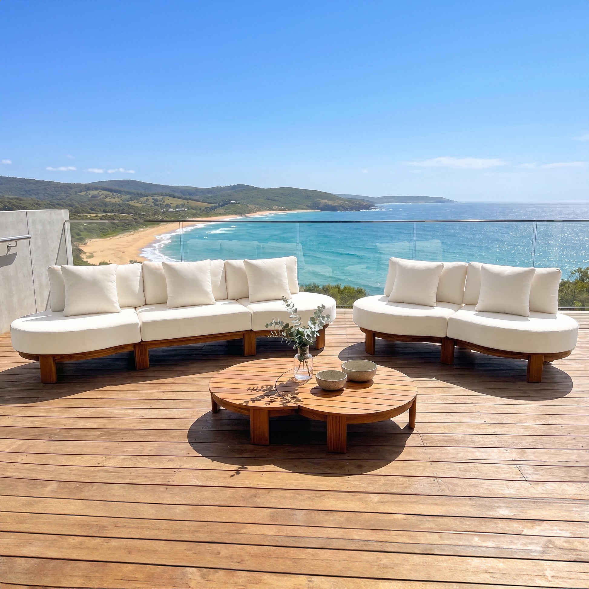 Outdoor sofa set with coffee table on a terrace overlooking the ocean and beach.