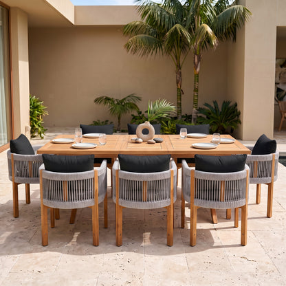 Outdoor wooden dining set with chairs on a patio with tropical greenery