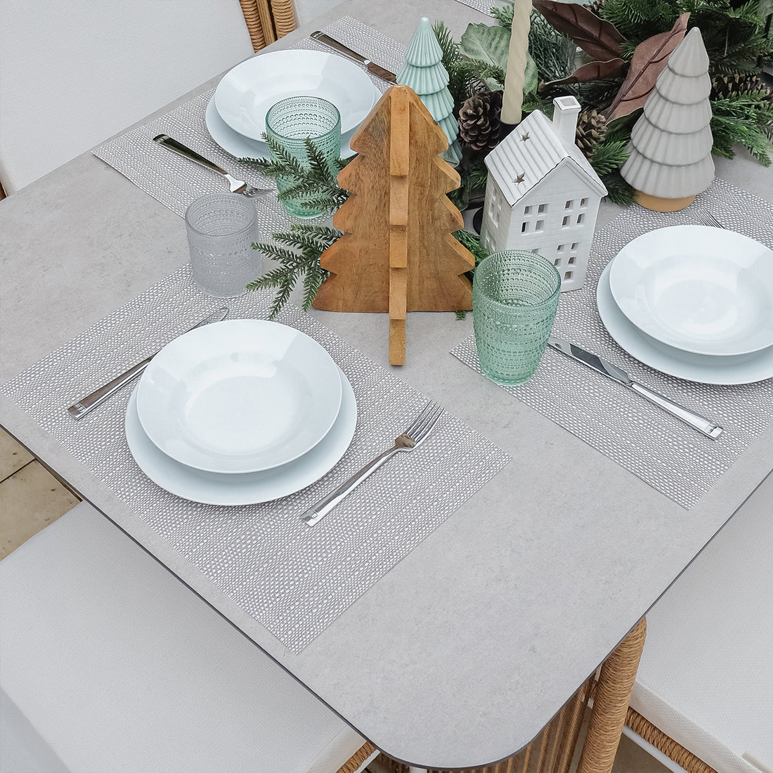 Craigie Premium 6-Seater Outdoor Dining Set with Ceramic Glass Table features a close-up of a glass and table setting, showcasing the elegant ceramic glass tabletop and spacious seating arrangement.