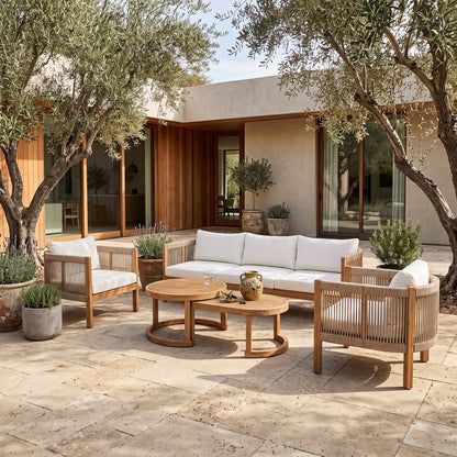 Outdoor furniture set arranged on a patio with plants and a modern house in the background