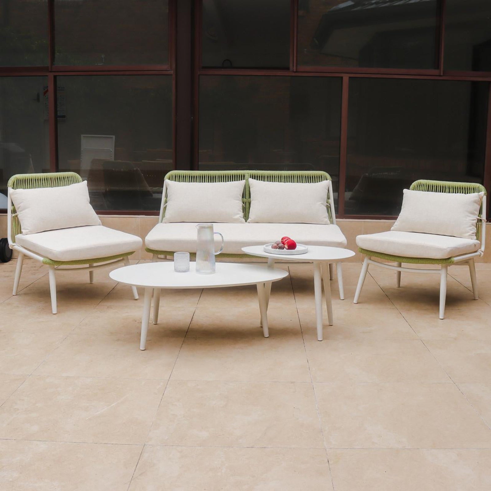 Lowanna 4pc Aluminium Rope Wicker Outdoor Lounge Set Mint Green features a two-seater sofa, armless chairs, and two coffee tables on a patio, showcasing modern design and comfort.