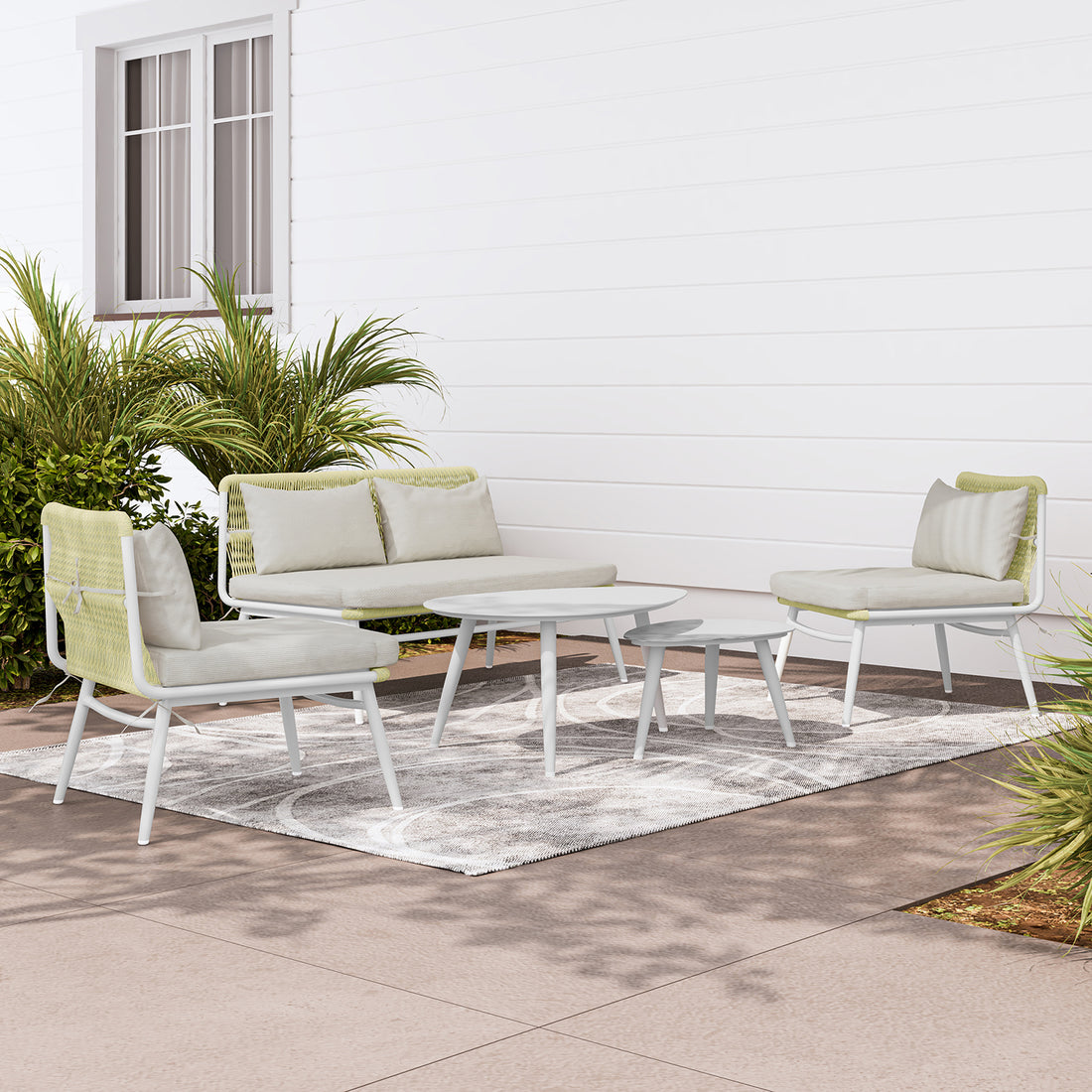 Lowanna 4pc Aluminium Rope Wicker Outdoor Lounge Set Mint Green, featuring a sturdy aluminium frame, plush cushions, and two coffee tables, elegantly arranged in a cozy patio setting with a potted plant nearby.