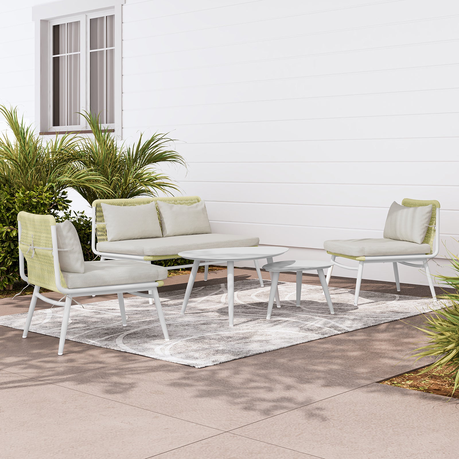 Lowanna 4pc Aluminium Rope Wicker Outdoor Lounge Set Mint Green, featuring a sturdy aluminium frame, plush cushions, and two coffee tables, elegantly arranged in a cozy patio setting with a potted plant nearby.