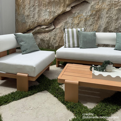 Modica outdoor sofa set with white cushions, timber-look frames, and natural stone backdrop