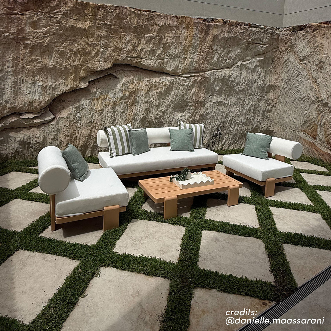 Modica outdoor sofa set with white cushions and timber frames on patterned stone paving