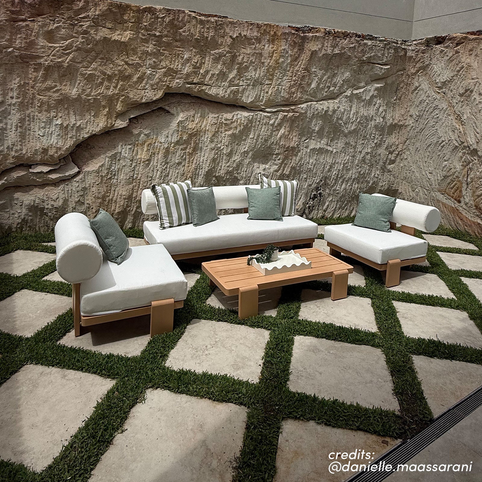 Modica outdoor sofa set with white cushions and timber frames on patterned stone paving