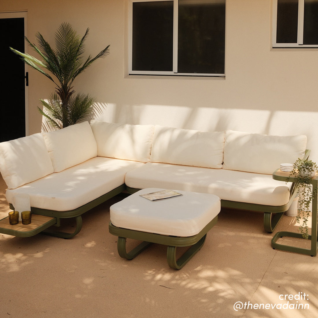 Paloma Modular Outdoor Lounge Set in Olive Green with cream cushions, L-shaped sectional, ottoman, and side tables on a paved