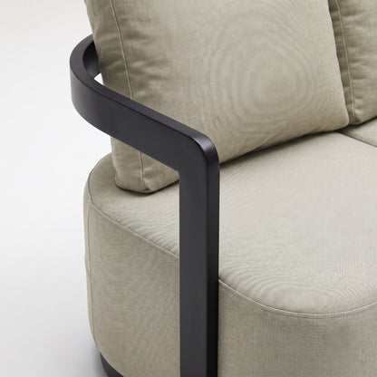 Close-up of part of a beige upholstered sofa with black frame on a white background