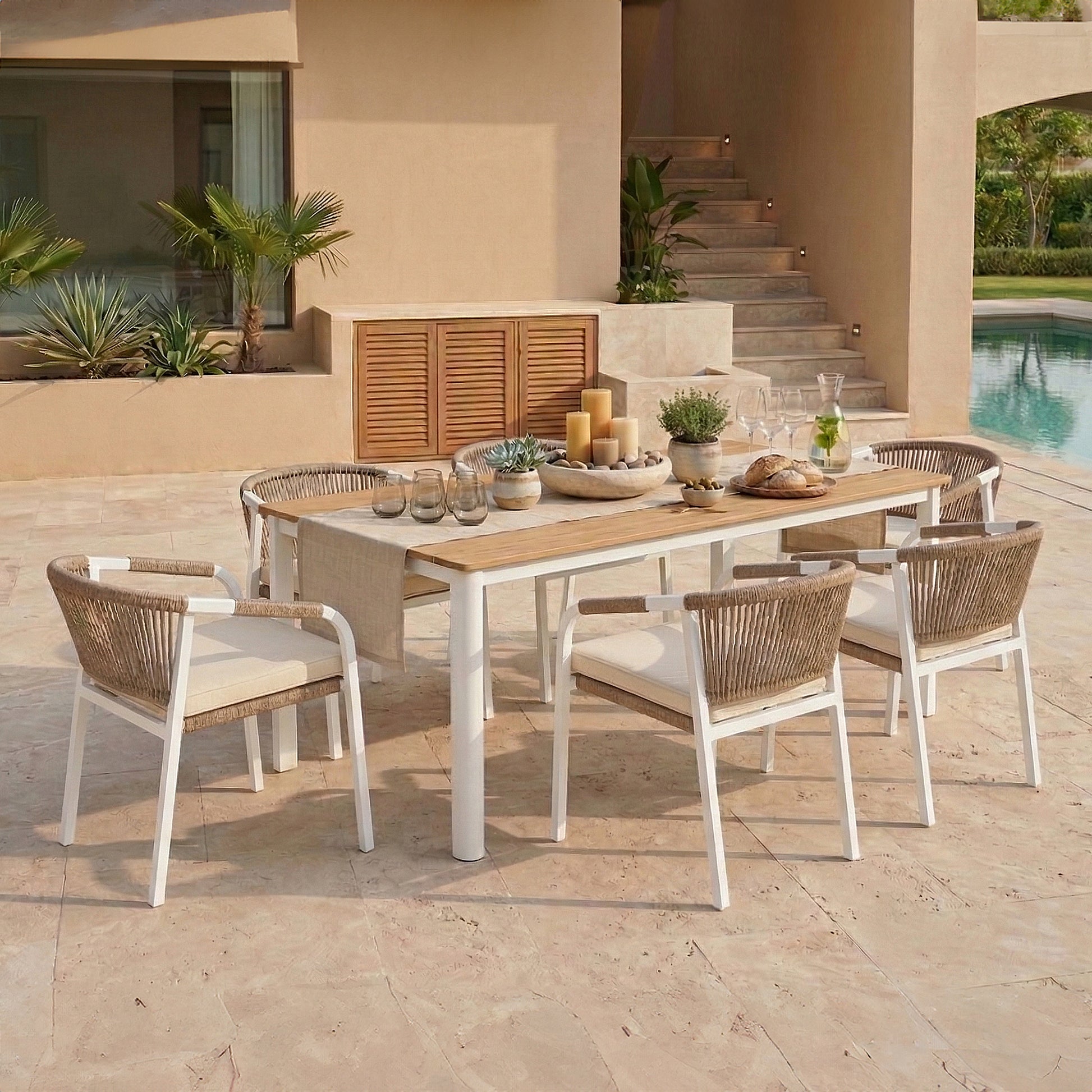 7-piece outdoor dining set featuring a timber-top table and six white aluminum armchairs with tan rope-woven backs and cream cushions.