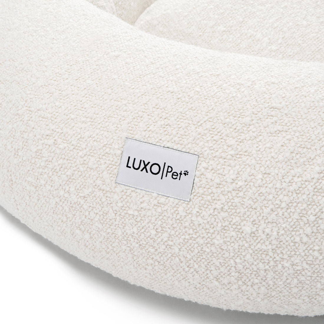 Kyra Medium Boucle Pet Bed – Light Beige Comfort, featuring plush boucle fabric and a supportive, sculpted design with a visible white label, ideal for modern décor and pet relaxation.