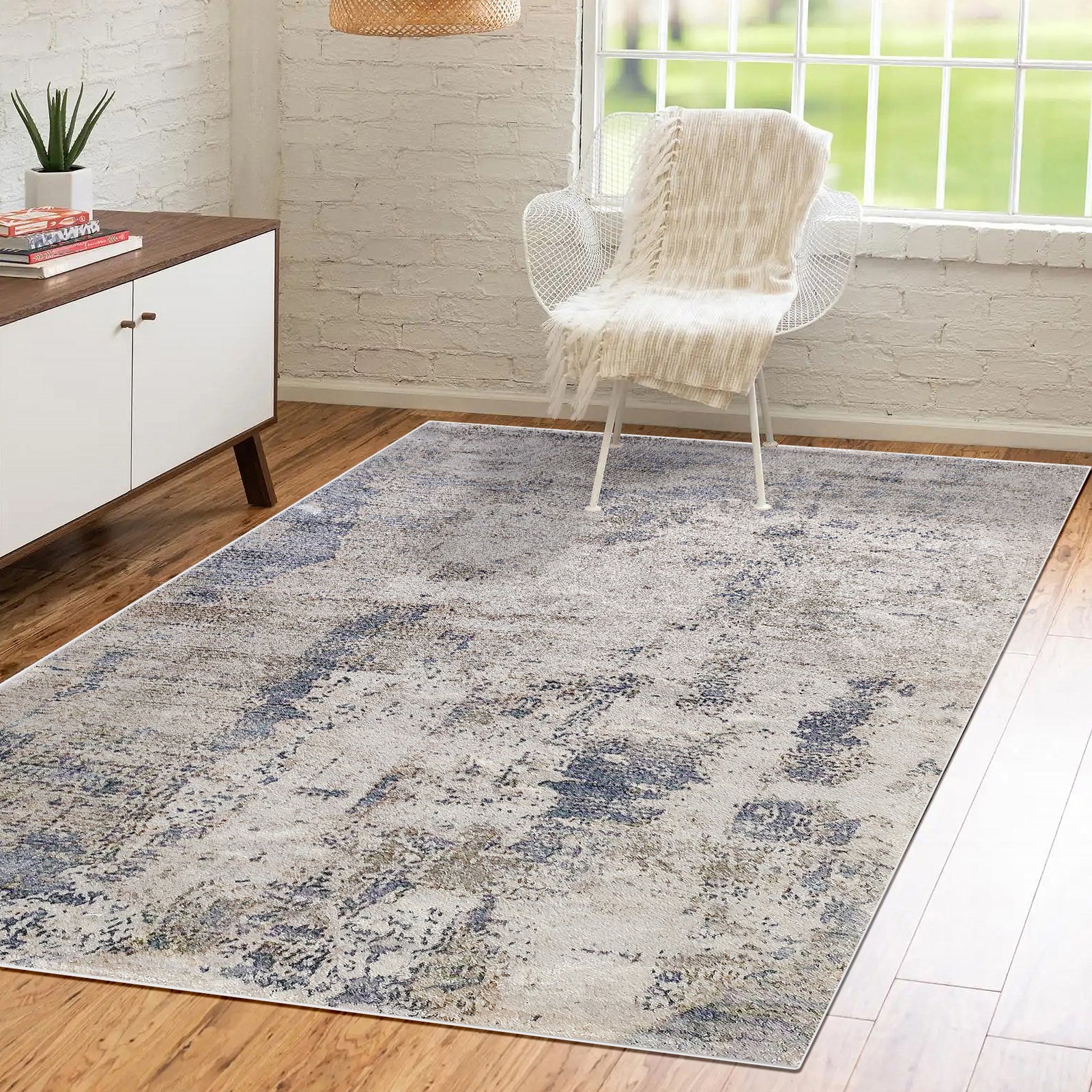 Ari Abstract Tufted Polyester Rug 200x300cm displayed in a cozy room, featuring a mottled pattern on warm-toned floors, complemented by a white lounge chair and mid-century sideboard.