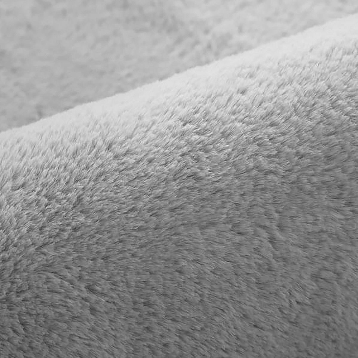 Azaliya 200x300cm Faux Rabbit Fur Floor Rug in Silver, showcasing a close-up of its soft, dense, short pile fibers with a gentle fold, highlighting its luxurious, cosy texture.