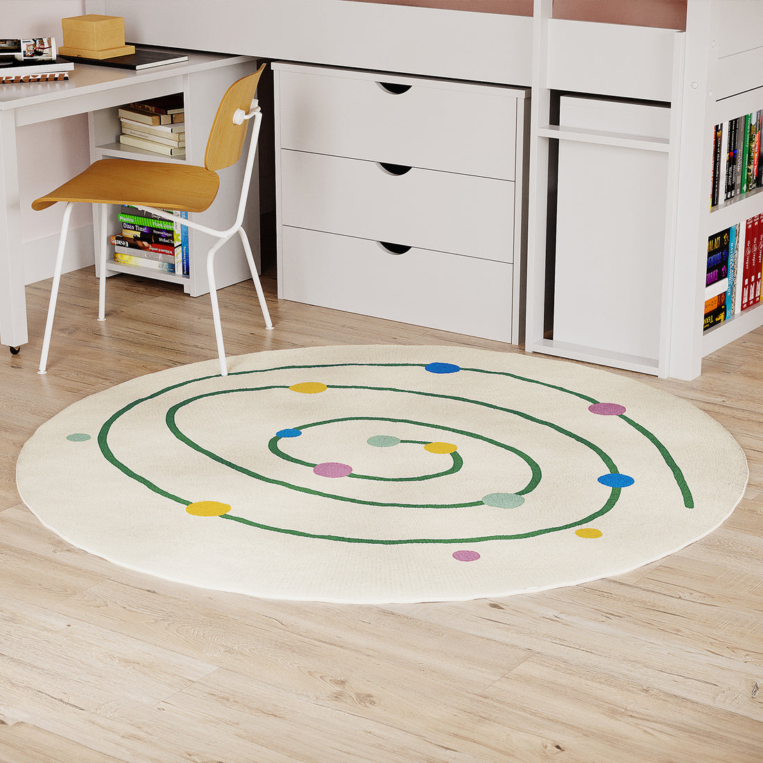 Callista 160cm Kids Round Colourful Spot Indoor Floor Rug with a green spiral and multicolored dots, placed centrally on light-wood flooring in a kid-friendly study area with modern furniture.
