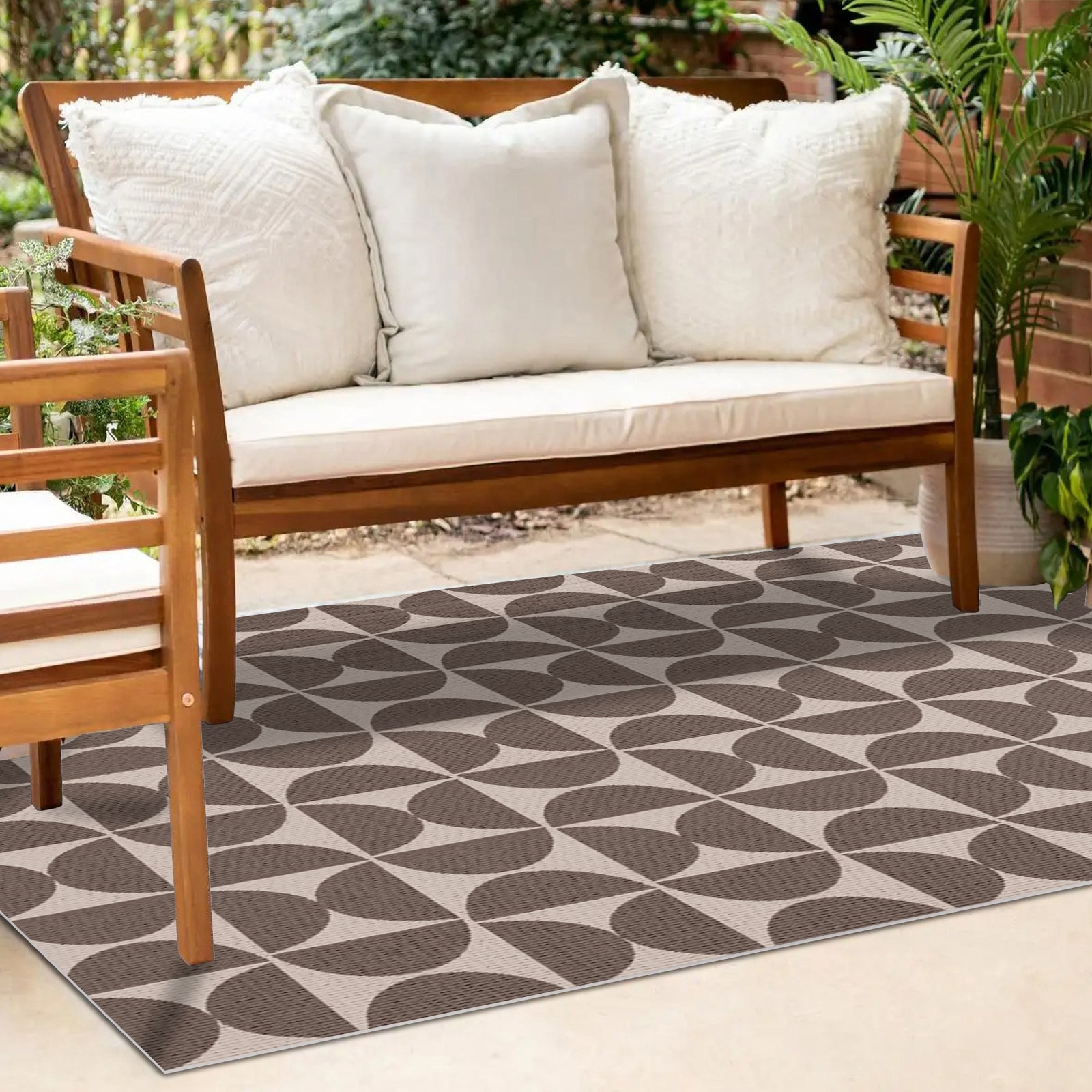 Dolly brown outdoor floor rug with geometric leaf pattern, displayed under wooden outdoor sofa with white cushions. 200 x