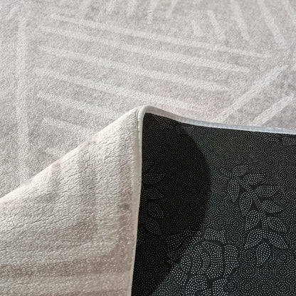 Close-up of Duved floor rug corner showing white textured pile and black dotted non-slip backing with bound edge