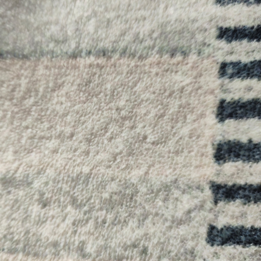 Close-up of Elimas 200x300cm Soft Contemporary Printed Floor Rug, showcasing its plush terrycloth surface with a subtle pattern and darker striped edge, highlighting its inviting texture and modern design.