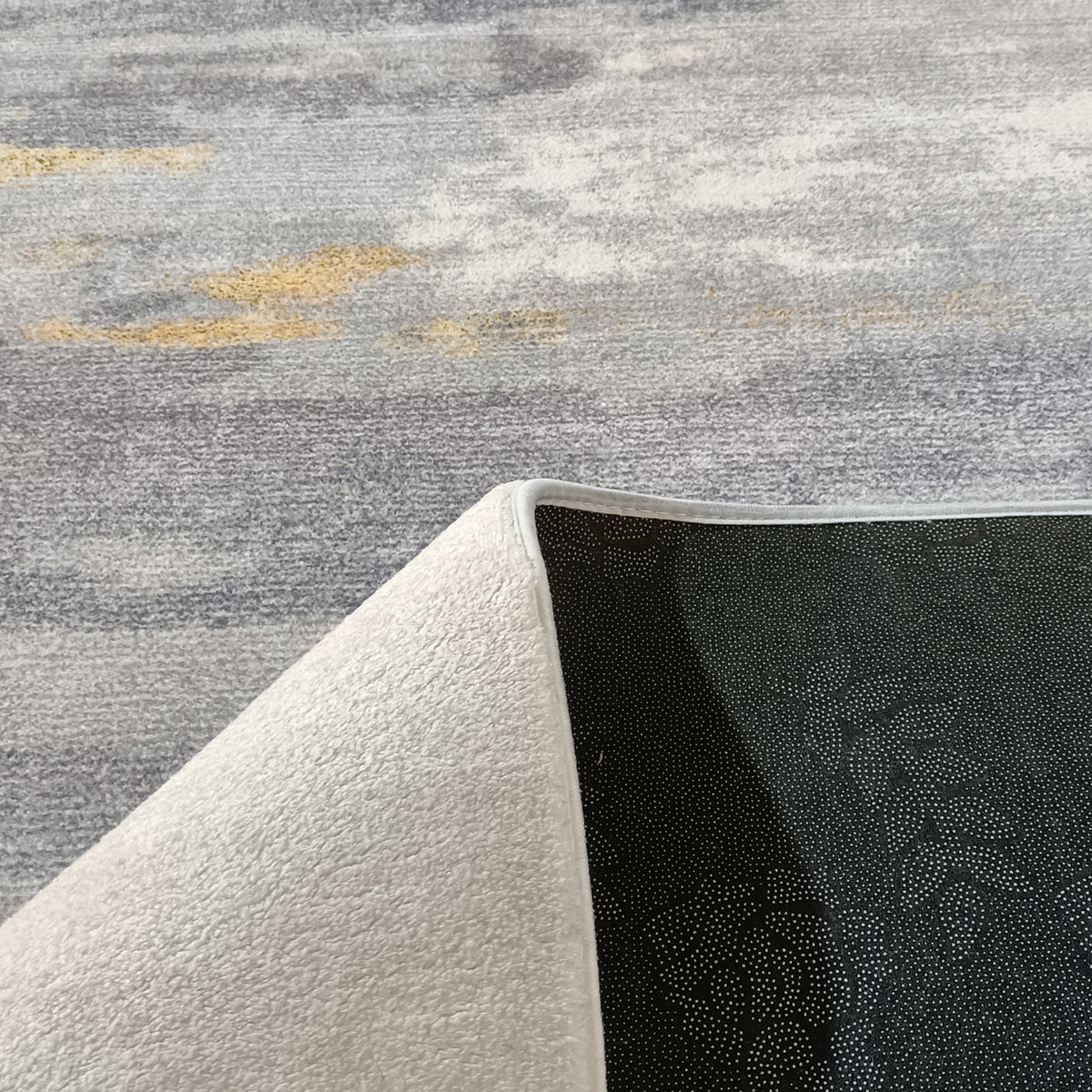 Getbo 160x230cm Medium Modern Indoor Floor Rug displayed with one corner flipped, showcasing its black, dotted non-slip backing and soft, white terry-style fabric top for a cosy, luxurious feel.