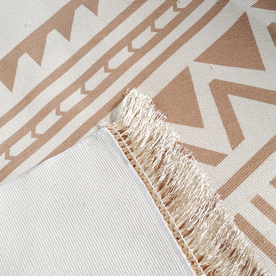 Kaley 160x230cm Woven Cotton Blend Tasseled Indoor Rug features cream and tan geometric patterns with a stitched edge and short fringes, showcasing its sophisticated and modern design.