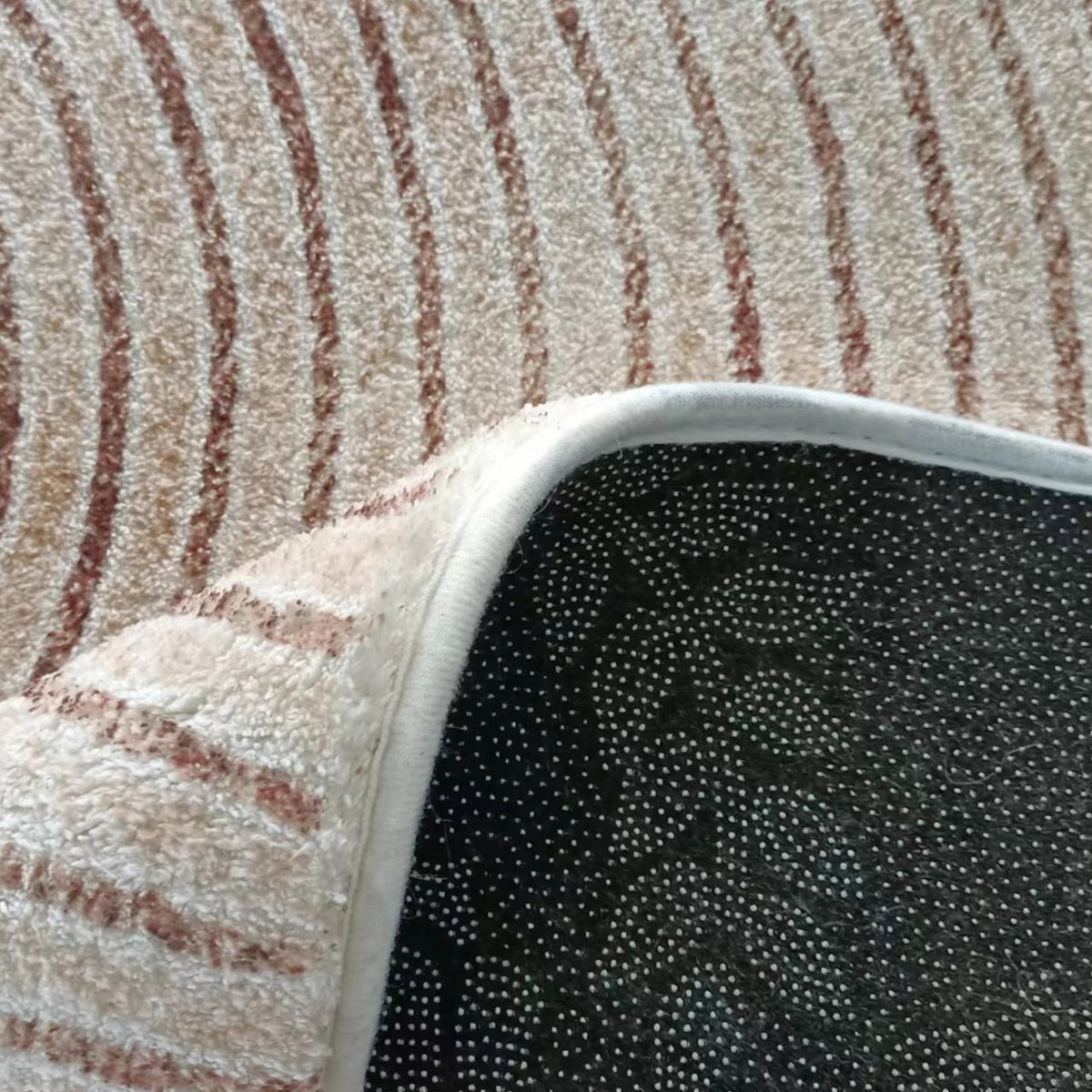 Close-up of Lunder Modern Abstract Floor Rug showing beige and brown striped pattern with white edge binding and black