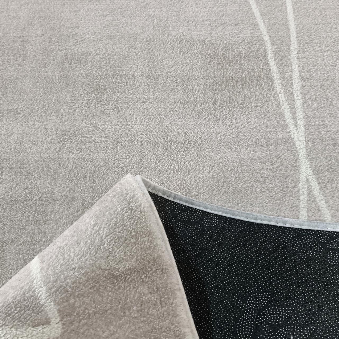 Manstad 160x230cm Modern Indoor Floor Rug, grey with low-pile texture, features one flipped corner revealing black non-slip dotted backing, showcasing its modern design and functionality.