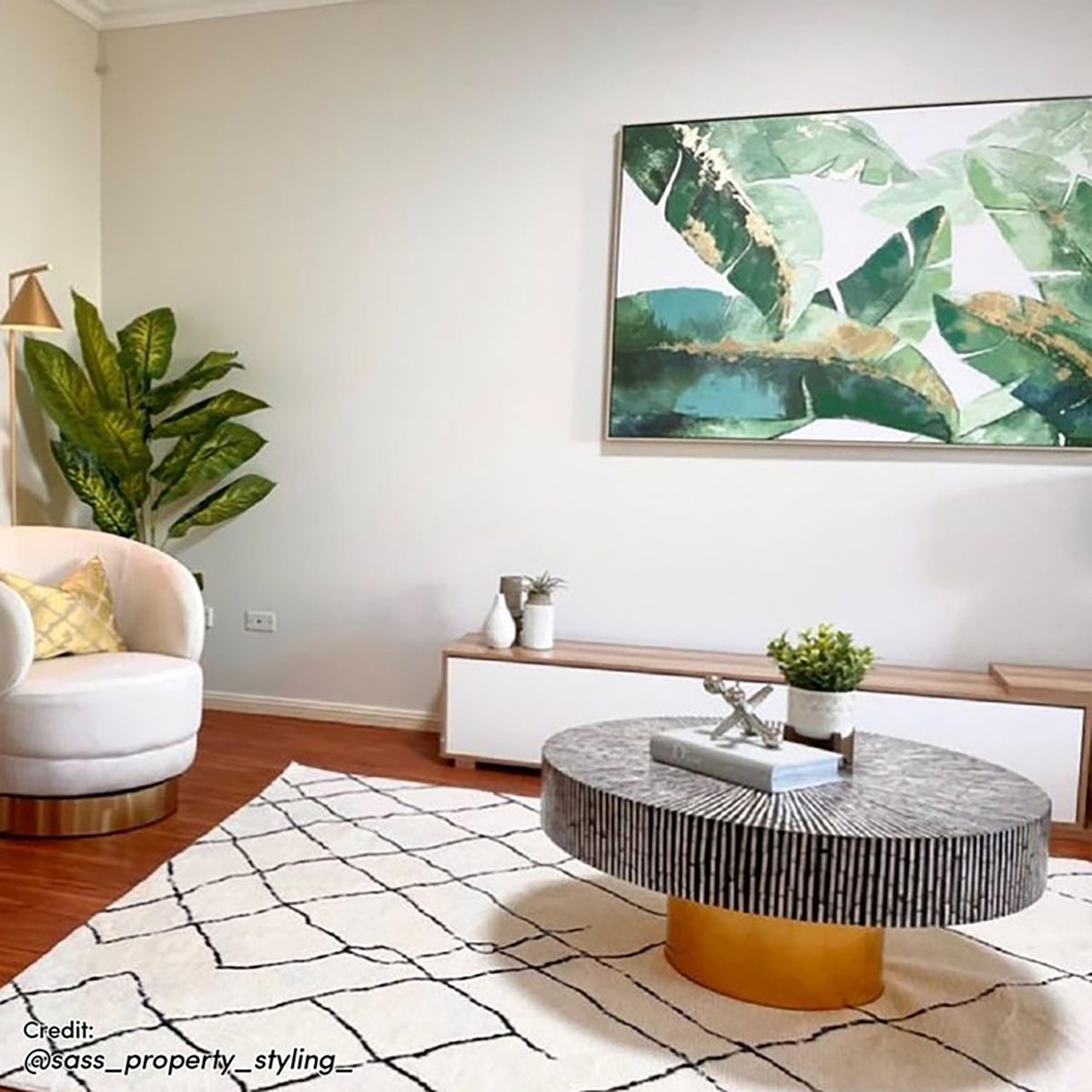 Melody Black and White Modern Floor Rug, 200 x 300cm, with black abstract lines on ivory, anchors a contemporary space with a swivel chair, coffee table, and leafy art.