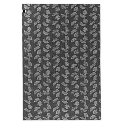 Melody Black and White Modern Floor Rug 200 x 300cm features a repeating botanical motif with light-gray leaf clusters on a dark gray background, ideal for adding style to high-traffic areas.