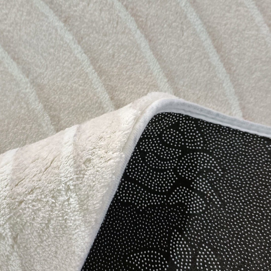 Meraker 200x300cm Modern Abstract Floor Rug with plush terry-cloth top and black non-slip underside, featuring white rubber dots for stability, ideal for adding warmth and comfort to living spaces.