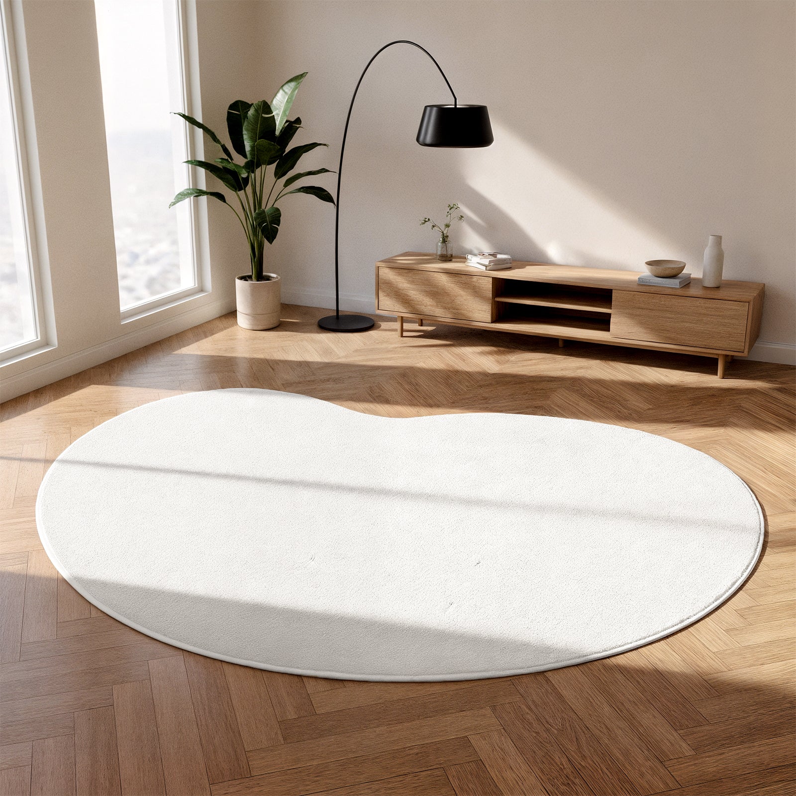 Parna Curved 240x330cm Large Soft Rug in Cream White in a bright living-room corner, featuring a unique curved design, under a black floor lamp, with a mid-century-style console nearby.