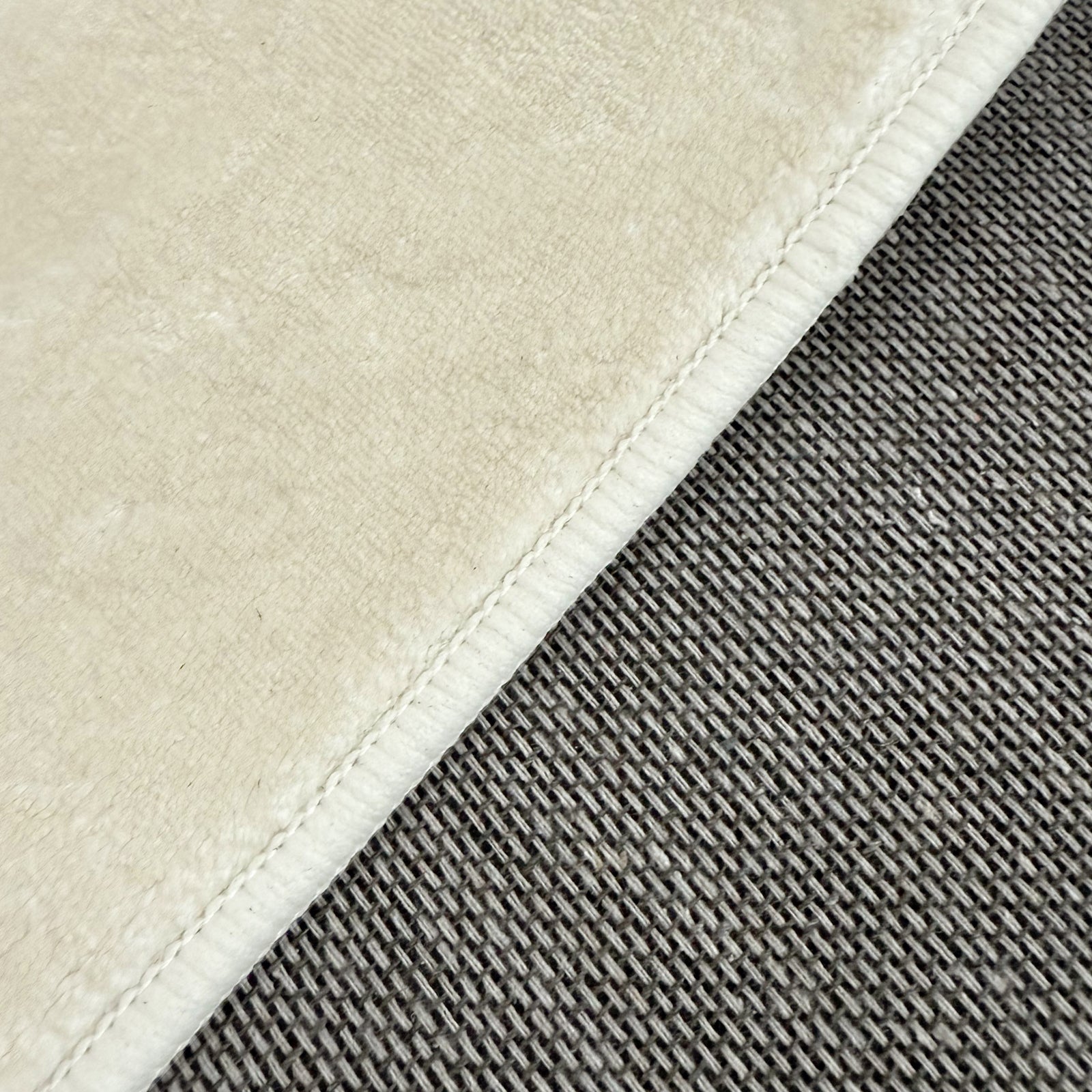 Pixie 240x330cm Wavy Large Shag Rug in Beige; close-up shows cream short-pile fabric and gray chunky woven texture, highlighting the rug's plush softness and durable design.