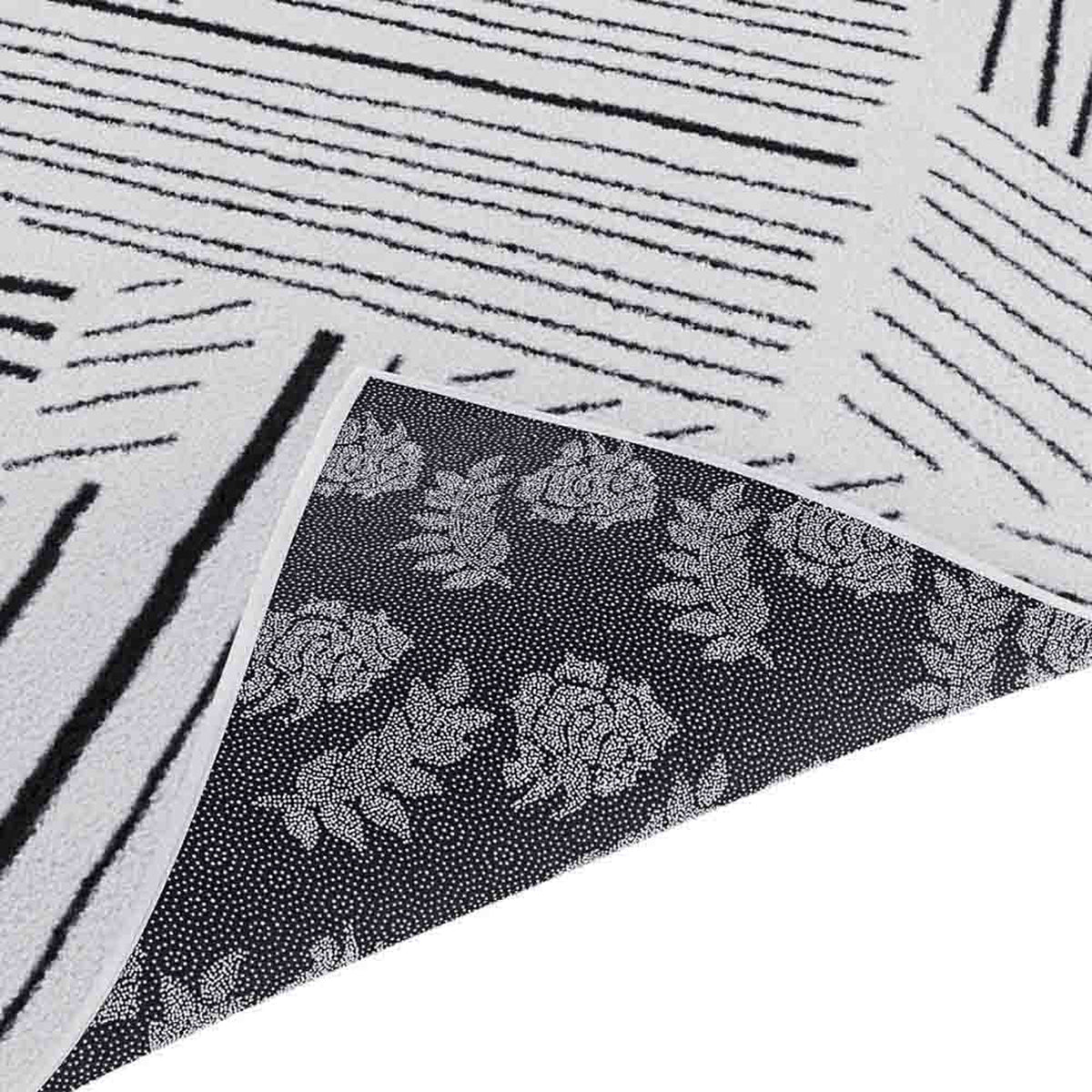 Vikki 200x300cm Large Abstract Contemporary Floor Rug shown with reversible sides; one side features irregular black stripes on off-white, the other displays rose-and-leaf motifs on a dark background.