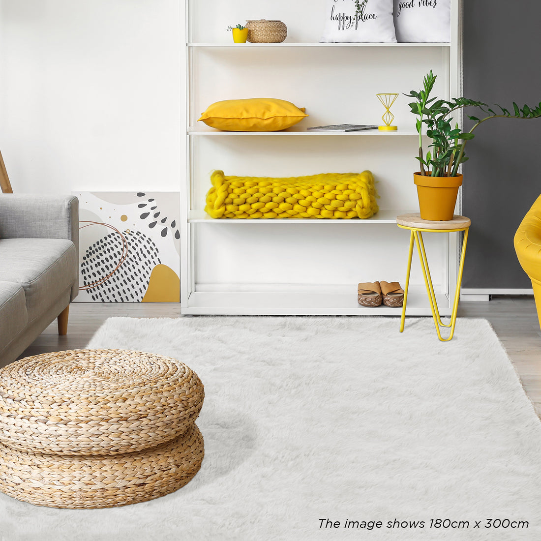Zubuin Shaggy Plush Fluffy Rectangular Fur Rug - White 160 x 230cm, featured in a cozy living room, covers the floor beneath woven-straw poufs, complementing a light gray sofa and yellow accents.
