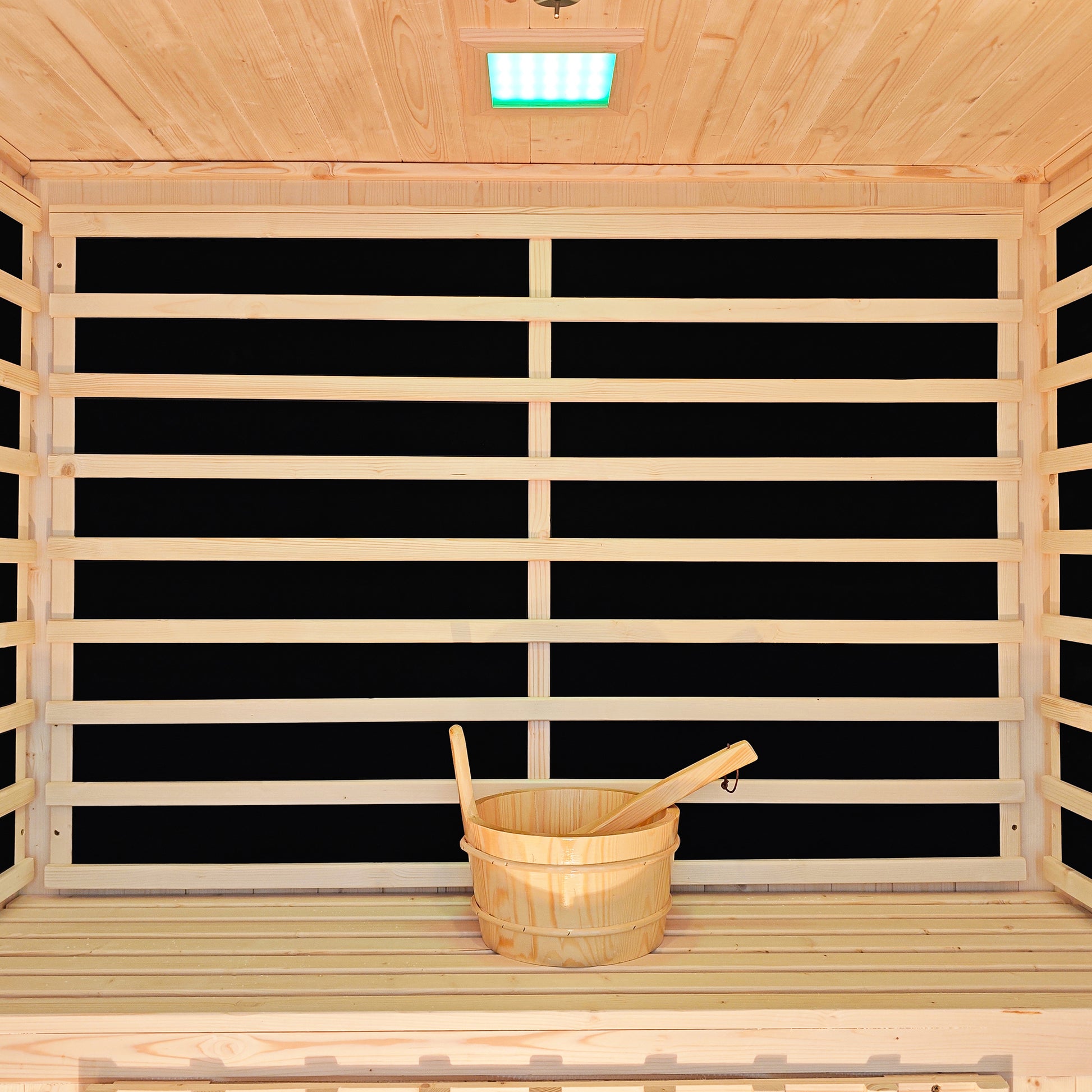Sauna interior with timber bench, bucket, ladle and infrared panels
