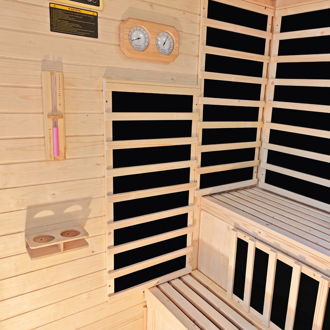 Interior of Kiima hybrid sauna showing natural fir wood walls, infrared heating panels, wooden benches, wall-mounted