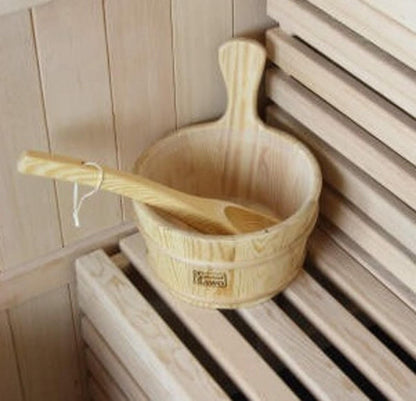 Kivi 6-Person Traditional Finnish Indoor Home Sauna set includes a wooden bucket and ladle on a slatted bench, perfect for authentic steam rituals in your personal wellness space.