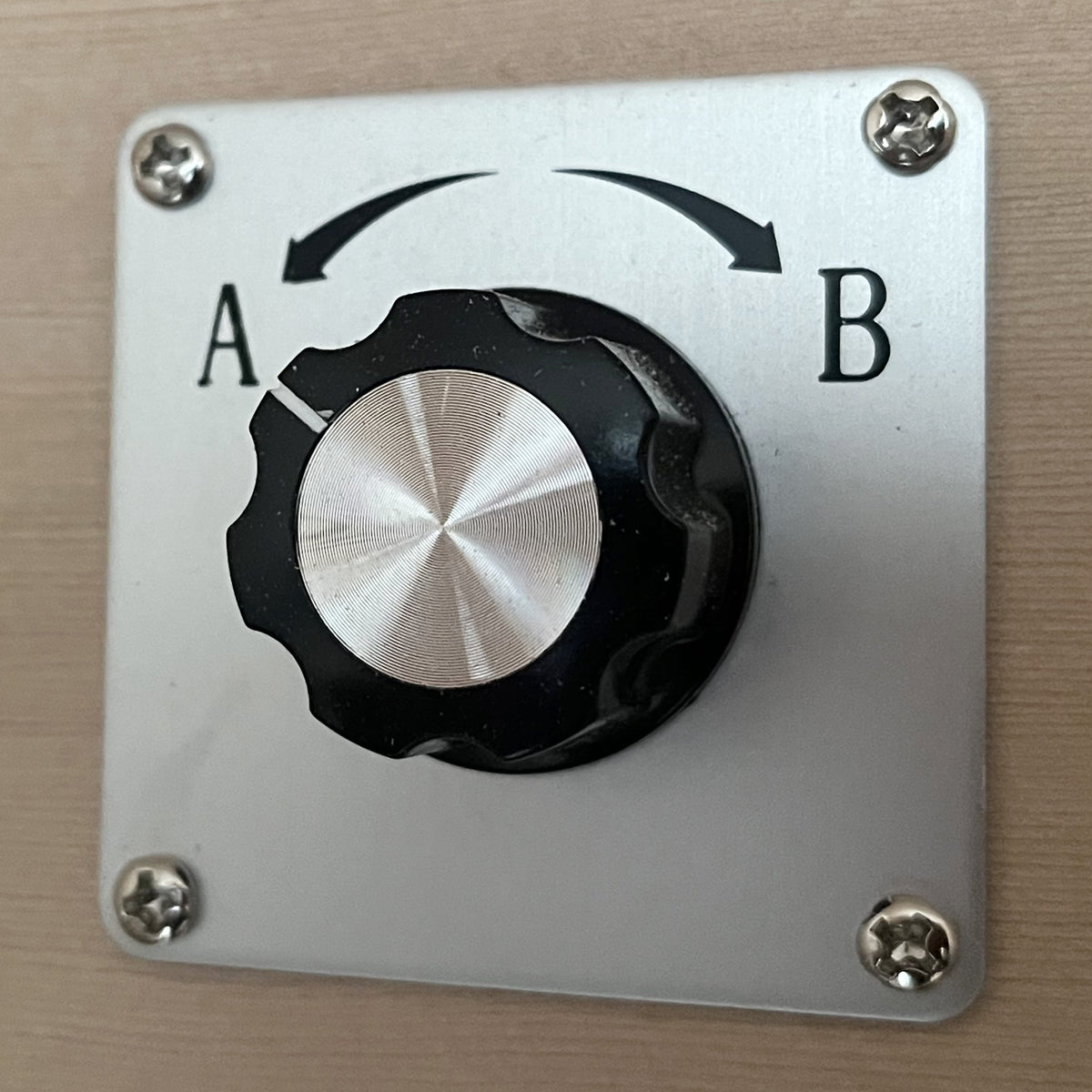 Close-up of a rotary selector switch, part of the Lue 3 Person Full Spectrum Curved Infrared Indoor Home Sauna, highlighting the simple two-position knob for easy control of sauna functions.