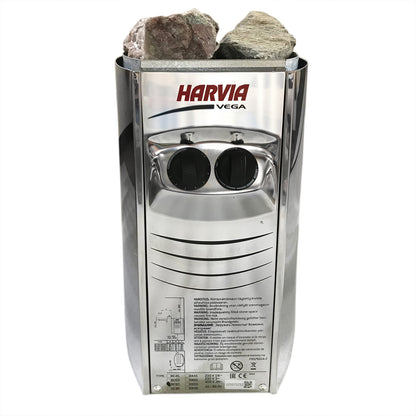 Luola 2 Person Pine Outdoor Barrel Sauna & Harvia Stove features a stainless-steel Harvia Vega electric heater with visible sauna stones and two black control knobs, offering relaxing outdoor sauna experiences.
