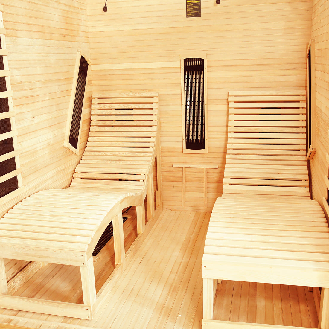 Metsa 3-Person Hybrid Carbon Fibre Infrared Home Sauna interior with light wood, two contoured slatted lounge chairs, and tall black infrared heater panels on walls, showcasing its modern design and spaciousness.
