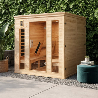 Metsa 3 Person Hybrid Carbon Fibre Infrared Home Sauna with light wood and tall glass panels, featuring L-shaped benches and an infrared heater, nestled amid greenery, offering serene relaxation.