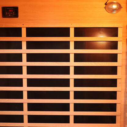Valo 3 Person Carbon Fibre Infrared Indoor Sauna interior features a black heating panel behind wooden slats, digital control near the ceiling, and a light or speaker fixture, offering luxurious home relaxation.
